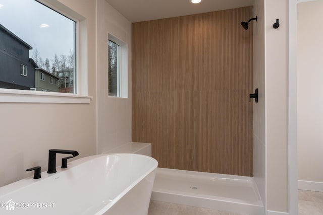 bathroom featuring a freestanding bath, a sink, and a shower stall