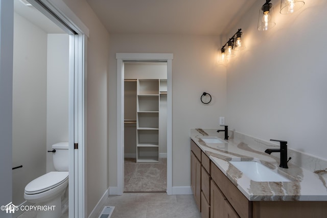 full bath featuring visible vents, a spacious closet, a sink, and toilet