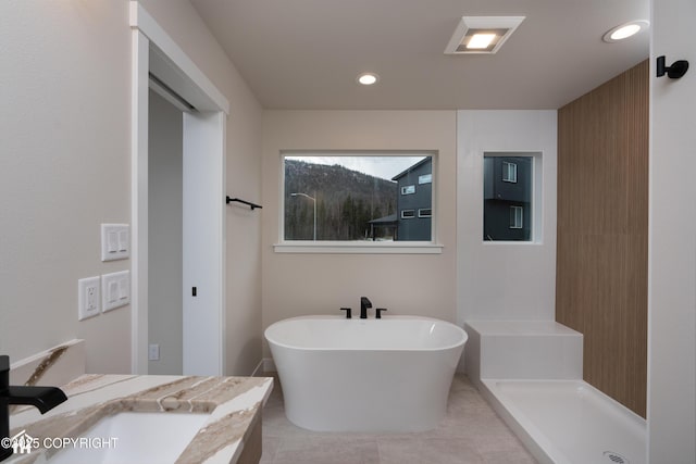 full bathroom with tile patterned flooring, a freestanding bath, vanity, a walk in shower, and recessed lighting