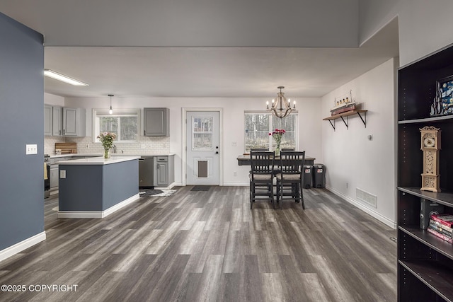 dining room with dark wood finished floors, baseboards, a notable chandelier, and visible vents