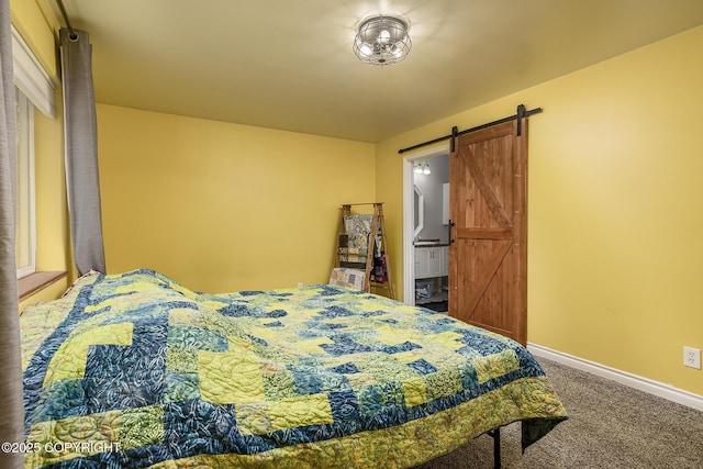 bedroom with baseboards, carpet flooring, and a barn door