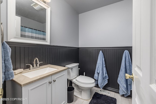 bathroom featuring wood finished floors, visible vents, vanity, and toilet