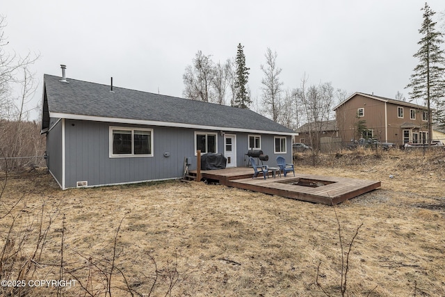 rear view of property featuring fence, a shingled roof, and a deck