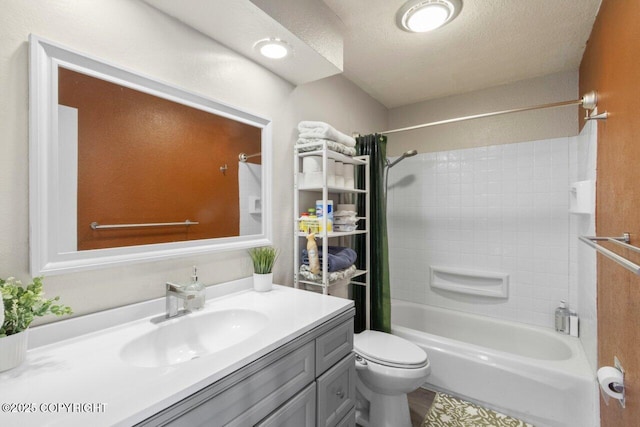 bathroom featuring toilet, bathtub / shower combination, a textured ceiling, and vanity