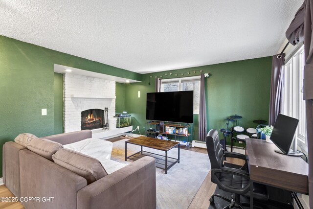 living area featuring light wood-type flooring, a fireplace, and a textured ceiling