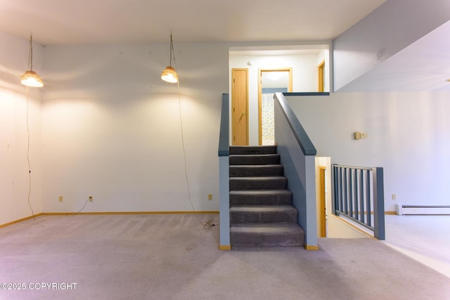 stairs with a baseboard heating unit, carpet floors, and baseboards