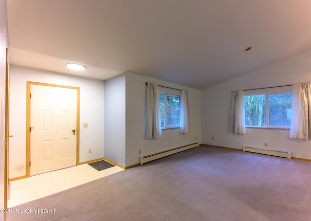 carpeted spare room featuring lofted ceiling, baseboard heating, and baseboards