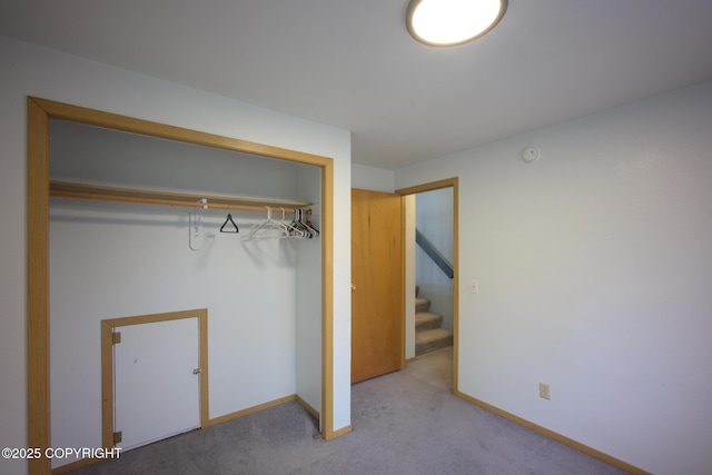 unfurnished bedroom featuring carpet floors, a closet, and baseboards