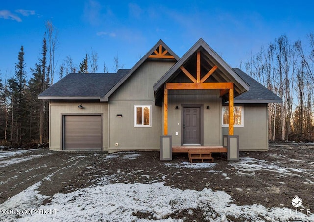 view of front of house with a garage and roof with shingles