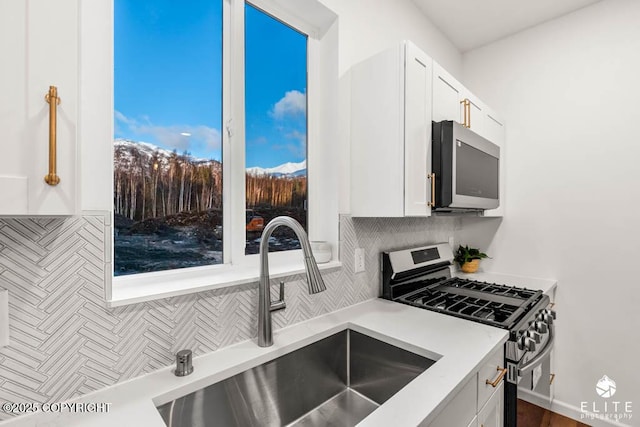 kitchen featuring appliances with stainless steel finishes, a sink, and white cabinets