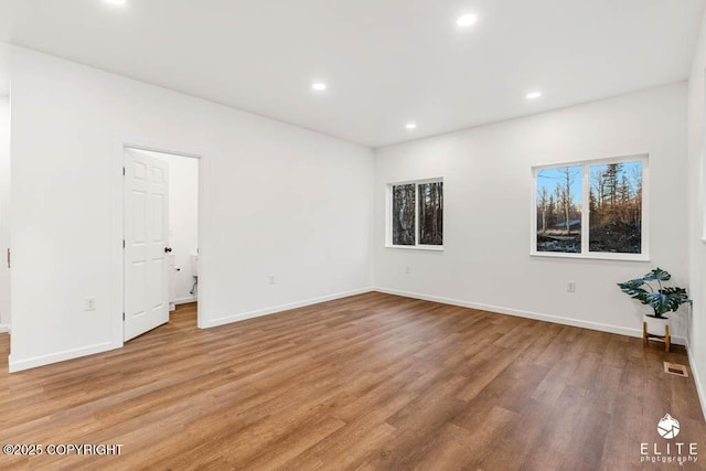 interior space with baseboards, wood finished floors, visible vents, and recessed lighting