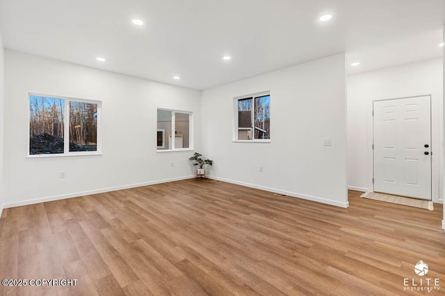 empty room with recessed lighting, baseboards, and light wood finished floors