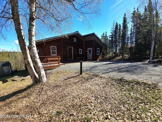 view of side of home with gravel driveway and central AC