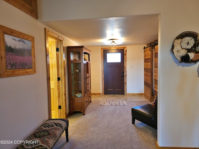 carpeted foyer with a barn door