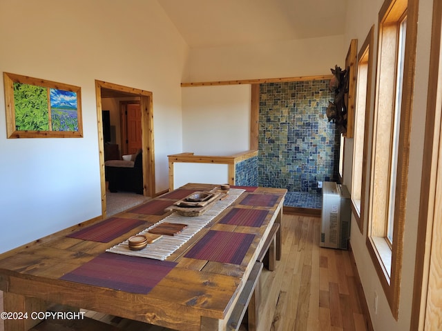 dining space featuring lofted ceiling and light wood-style flooring