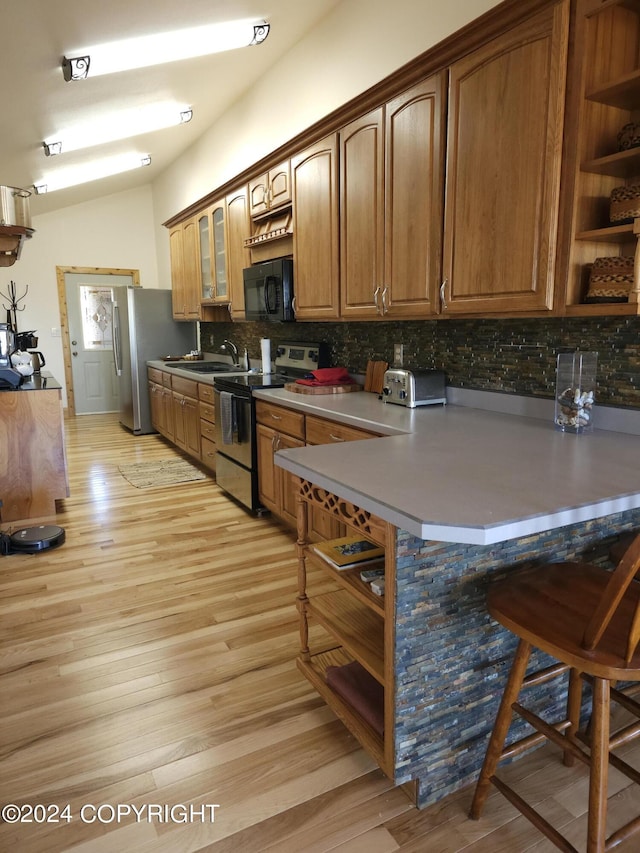 kitchen with light wood-style floors, stainless steel appliances, open shelves, and decorative backsplash