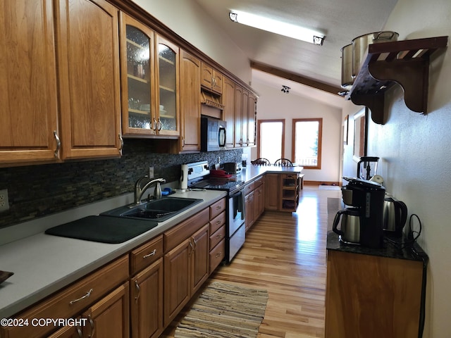 kitchen featuring vaulted ceiling with beams, black microwave, a sink, stainless steel range with electric cooktop, and glass insert cabinets