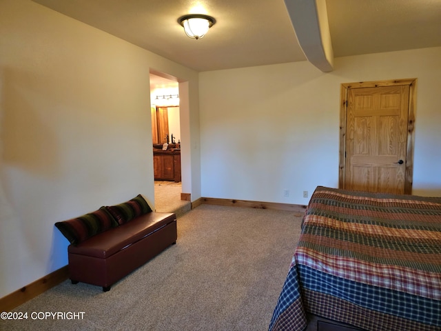 carpeted bedroom with baseboards and connected bathroom