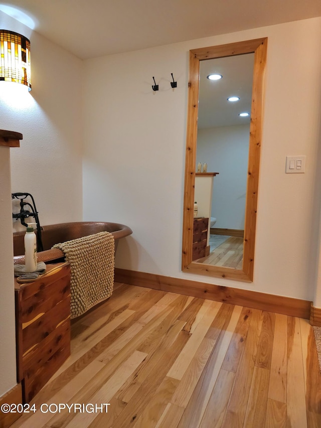 living area featuring baseboards, hardwood / wood-style floors, and recessed lighting