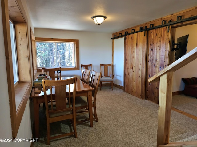 dining area with stairs, a barn door, and carpet