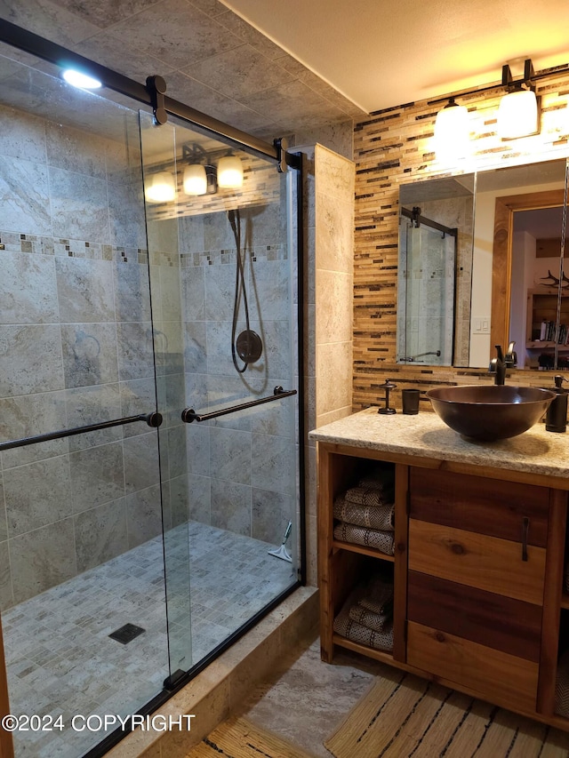 full bath with a stall shower and vanity