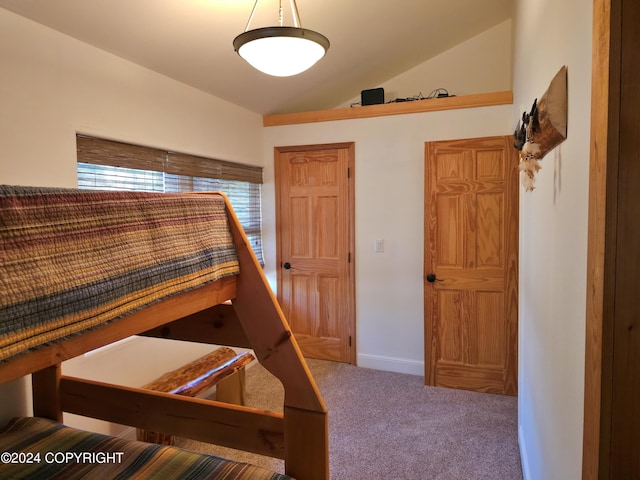 bedroom with vaulted ceiling, carpet floors, and baseboards