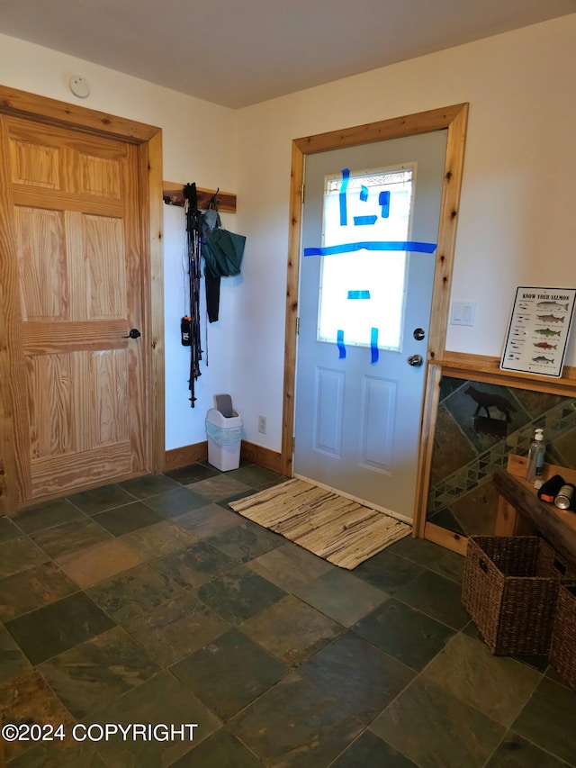 entrance foyer featuring stone finish flooring and baseboards