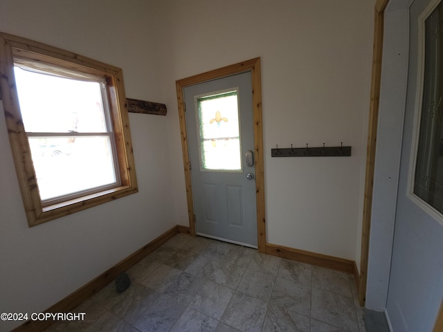 doorway to outside featuring baseboards