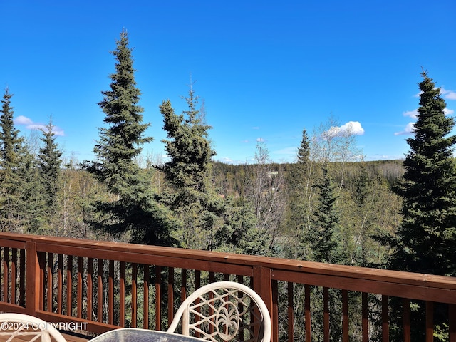 wooden terrace featuring a wooded view