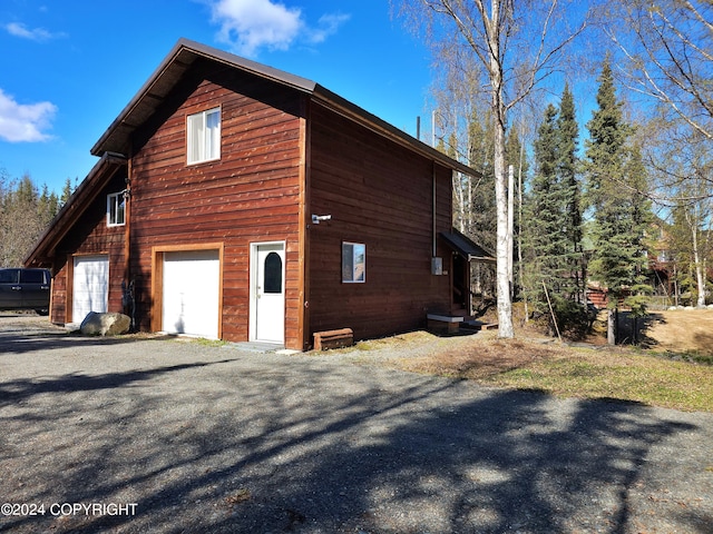 view of home's exterior with gravel driveway