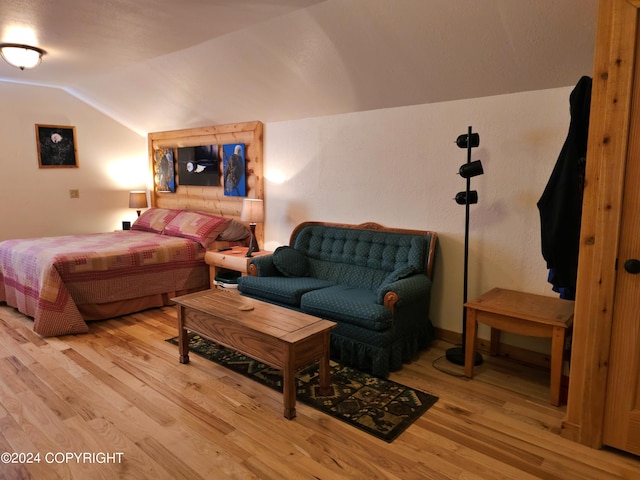 bedroom with lofted ceiling and light wood-style flooring