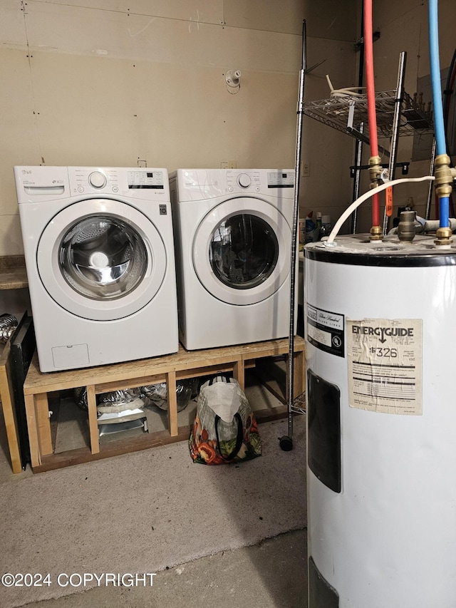 clothes washing area featuring water heater and washer and clothes dryer