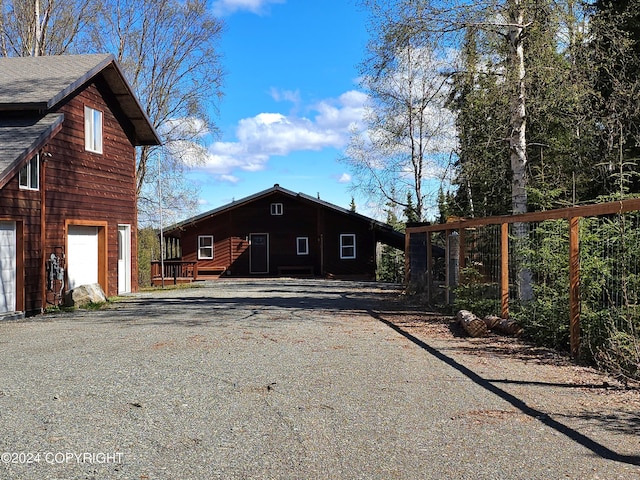 view of property exterior featuring a garage, driveway, and a shingled roof