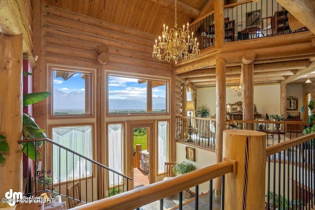 interior space with high vaulted ceiling, rustic walls, wood ceiling, and an inviting chandelier