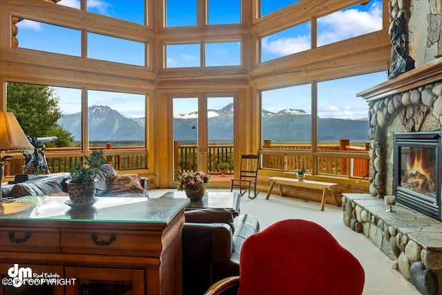 sunroom / solarium featuring a wealth of natural light, a fireplace, and a mountain view