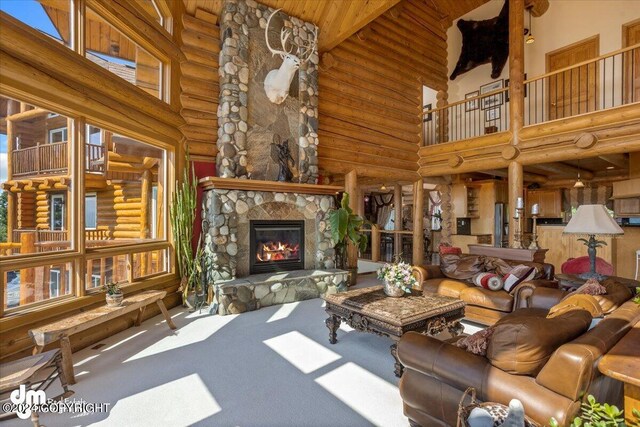 living room with carpet floors, a stone fireplace, and a towering ceiling