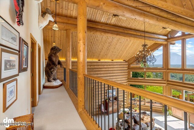 hall with a chandelier, wooden ceiling, beamed ceiling, high vaulted ceiling, and a mountain view