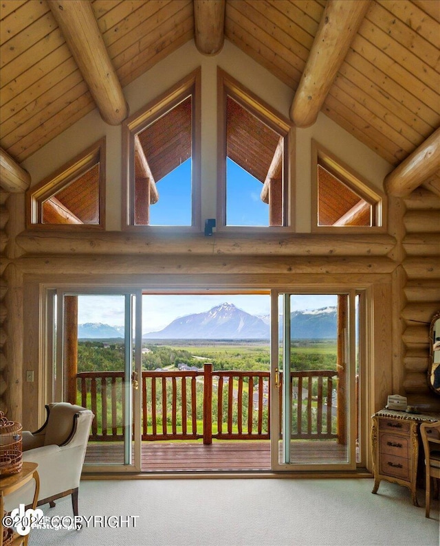 interior space with carpet floors, a mountain view, and beam ceiling