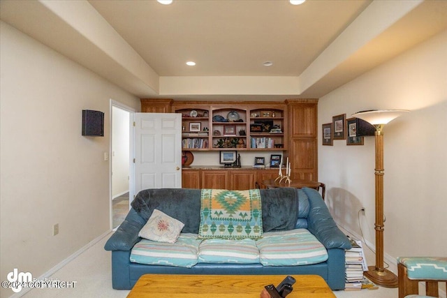 living area with carpet floors, recessed lighting, a tray ceiling, and baseboards