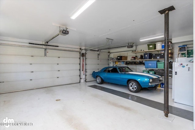 garage with a garage door opener and freestanding refrigerator