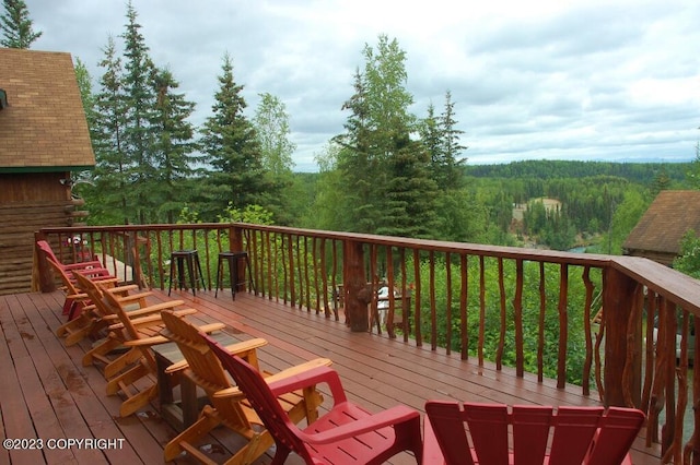 wooden deck with a wooded view