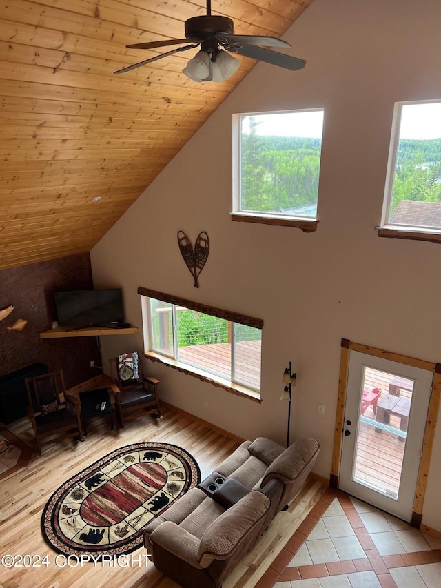 living room with plenty of natural light, tile patterned flooring, wooden ceiling, and a ceiling fan