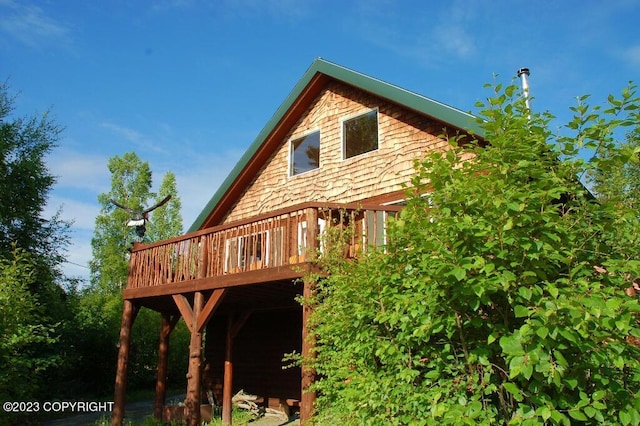 rear view of house featuring a wooden deck