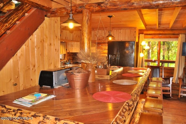 dining space with wooden ceiling, wood walls, wood finished floors, stairway, and beamed ceiling