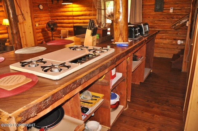 kitchen featuring dark wood-type flooring, rustic walls, and white cooktop