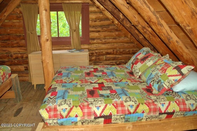 bedroom featuring wood-type flooring and log walls