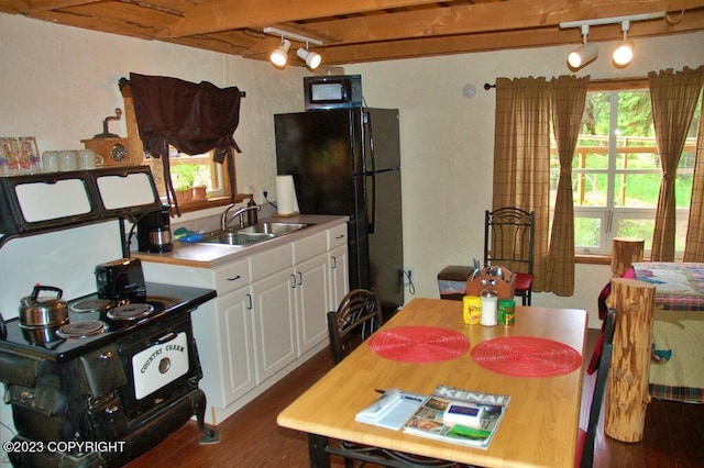 kitchen with black appliances, dark wood-style flooring, a wealth of natural light, and a sink