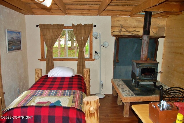 bedroom with a wood stove, wooden ceiling, wood finished floors, and beam ceiling