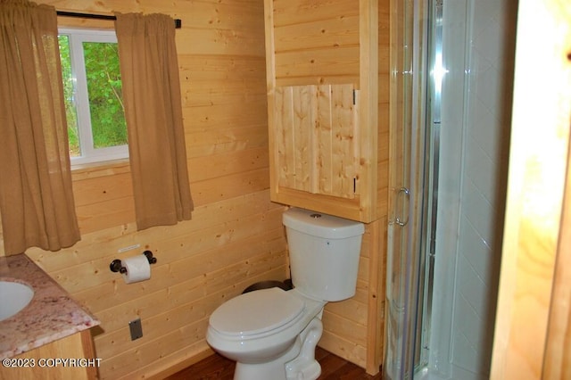 bathroom with toilet, wooden walls, walk in shower, and vanity