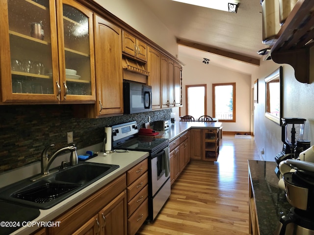 kitchen featuring vaulted ceiling with beams, glass insert cabinets, stainless steel range with electric cooktop, a sink, and black microwave